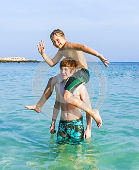 Two boys and brothers strike a funny pose in the ocean