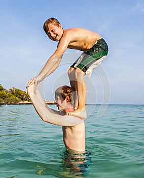 Two boys and brothers strike a funny pose in the ocean