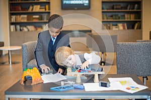 Two boys in business dress playing with toys on
