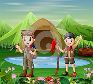 Two boys in camping uniform exploring a nature