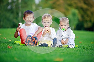 Two boys eating ice cream, youngest brother sucking pacifier