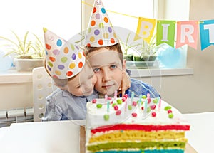 Two boys embrace and have good relationship. Birthday party and cake