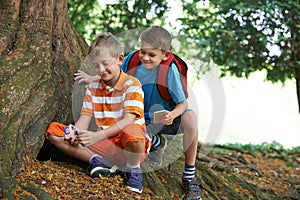 Two Boys Finding Item Whilst Geocaching In Forest