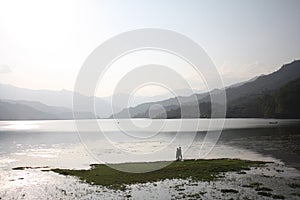 Two boys fishing in a silver lake in Pokhara Nepal