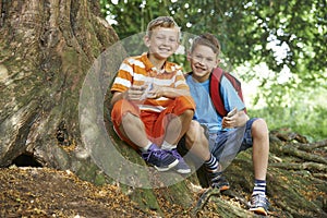 Two Boys Geocaching In Woodland