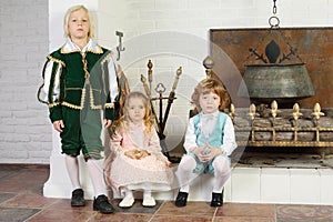 Two boys and girl in medieval costumes pose near