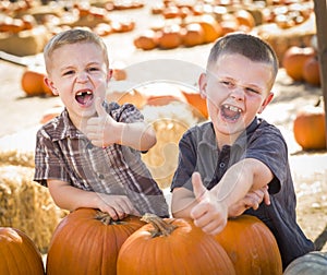 Two Boys Give a THumbs Up at the Pumpkin Patch on a Fall Day