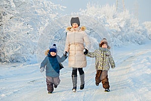 Two boys and grandmother in the winter forest