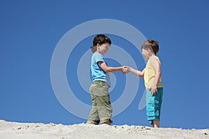 Two boys greet on sand photo