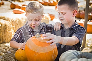 Two Boys Having Fun at the Pumpkin Patch on a Fall Day