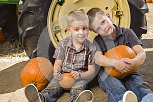 Two Boys Having Fun at the Pumpkin Patch on a Fall Day