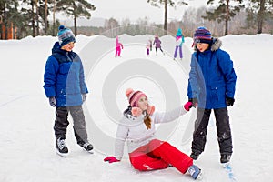 Two boys helps girl learn to skate