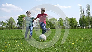 Two boys hit the ball on green playfield