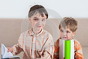 Two boys holding books in their hands