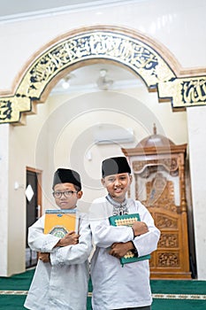 Two boys holding holy quran