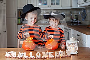 Two boys at home, preparing pumpkins for halloween