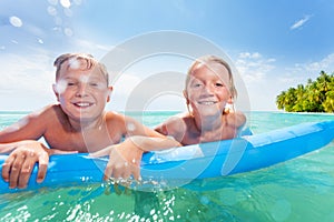 Two boys on inflatable matrass in the sea