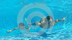 Two Boys Jumping Into Pool Then Swims Underwater To Camera