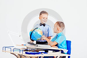 Two boys are learning globe for desk at school