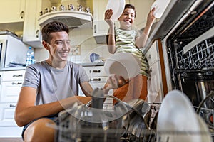 Two boys loading the dishwasher together