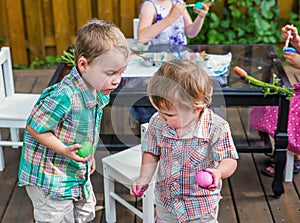 Two Boys Looking at Each Others Colored Easter Eggs