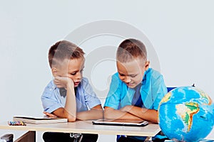 The two boys are looking at Internet Tablet school