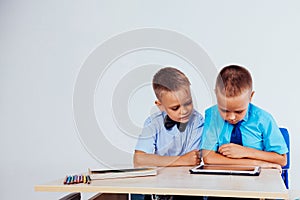 The two boys are looking at Internet Tablet school