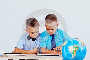 The two boys are looking at Internet Tablet school