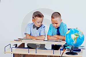 The two boys are looking at Internet Tablet school