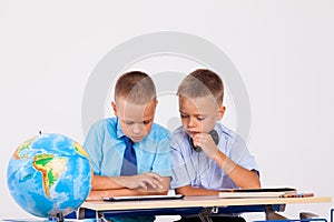 The two boys are looking at Internet Tablet school