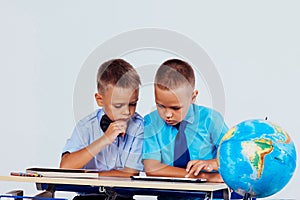 The two boys are looking at Internet Tablet school