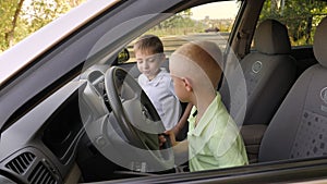 Two boys play in the car while driving, they imagine themselves to be drivers.