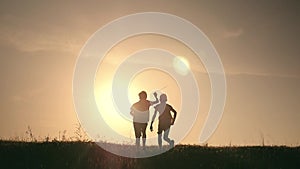 Two boys play with a wooden plane at sunset. Silhouette of children playing with airplane. Dreams of flying. The concept