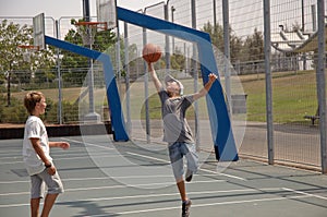 Two boys playing basketball .