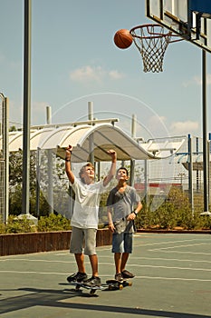 Two boys playing basketball .