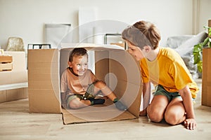 Two Boys Playing with Boxes in New Home