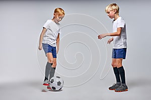 Two boys playing soccer, enjoying sports game