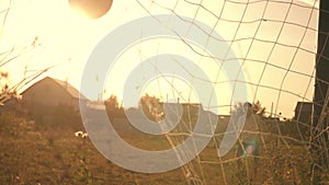 Two boys playing soccer at sunset. A soccer ball is hitting. Football goal. Children`s dreams of victories