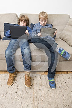 Two boys playing video games on a tablet computer