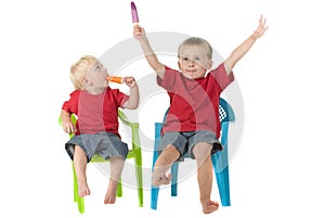 Two boys with popsicles on lawn chairs