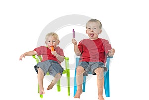Two boys with popsicles on lawn chairs