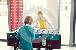 Two boys in school break playing tabletop football