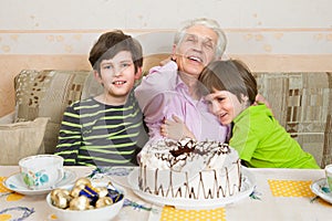 Two boys and senior man with a holiday cake