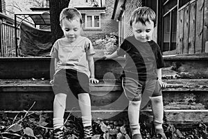 Two Boys Sitting Outside Together