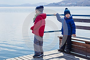 Two boys standing on a pontoon in the spring