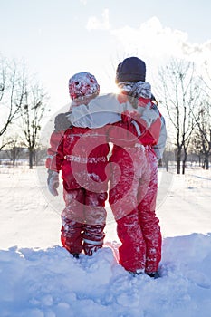 Two boys standing togerher at the snow on park photo