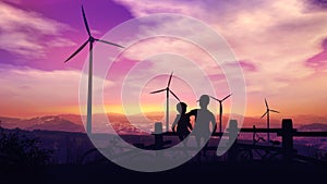 Two boys at sunset look at wind turbines