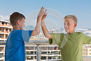 Two boys in T-shirts are greet each other photo