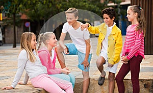 Two boys and three girls are talking about play on walk