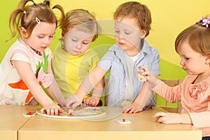 Two boys and two girls doing together wooden